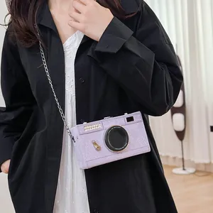 Close-up detail of a vintage camera-shaped purple crossbody bag with silver chain strap