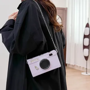 Side view of a lavender vintage camera-shaped hard box crossbody bag with silver chain