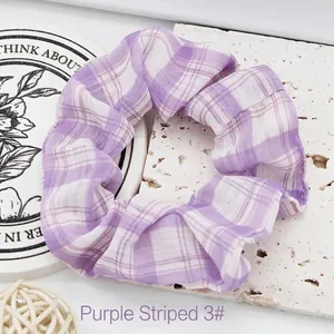 Purple and white plaid fabric scrunchie with a soft ruffled texture shown in detail view.