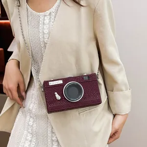 Detailed macro view of a vintage burgundy camera-shaped hard box crossbody bag on model