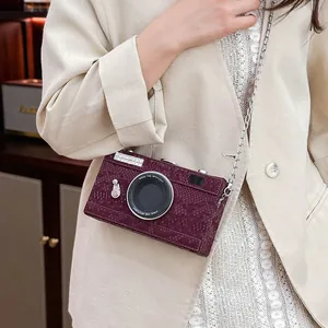 Detailed view of the vintage camera-shaped hard box crossbody bag in burgundy leather