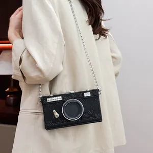 Close-up of a black vintage camera-shaped crossbody box bag with a silver chain strap