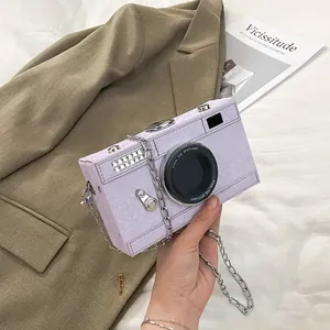 Close-up of retro camera-shaped hard box bag with purple snakeskin texture and chain