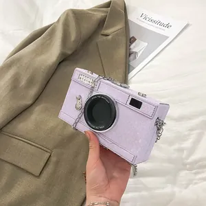 Lavender purple camera-shaped box bag with snakeskin texture and metal chain.