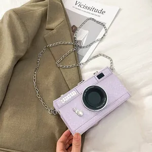 Detail view of purple vintage camera-shaped crossbody bag with silver chain strap