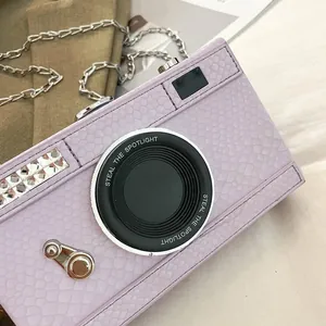 Close-up of a retro camera-shaped lavender crossbody bag with crocodile texture and silver chain