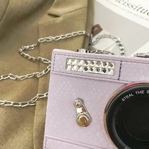 Close-up of a purple vintage camera-shaped box bag with a silver chain shoulder strap