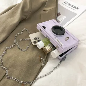 Internal storage of a purple camera-shaped box bag with a phone and cosmetic bottles