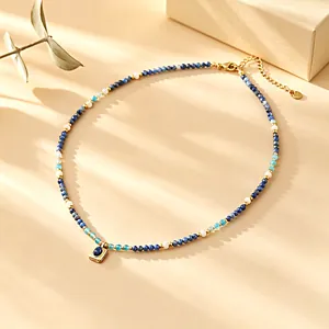 Detailed top view of a natural stone beaded lapis lazuli necklace with a gold pendant