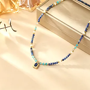 Close-up of beaded necklace with natural lapis lazuli stone and gold-plated pendant