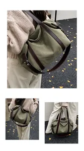 Vista dettagliata di una borsa tote in tela verde oliva con spalline marroni indossata da modella