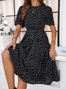 Detail view of a black polka dot midi dress with elegant waist tie and short sleeves.