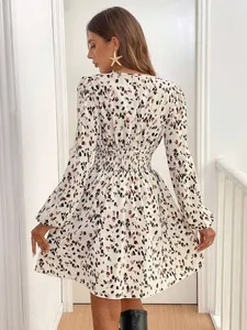Back view of leopard print long-sleeved mini dress featuring a smocked elastic waist