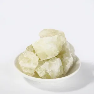 Macro detail of natural raw green crystal aroma stones placed on a white ceramic plate.