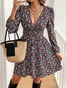 Detailed view of long sleeve ditsy floral mini dress with V-neckline and straw bag