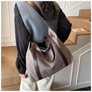 Dettaglio di una borsa tote in tela vintage con eleganti manici in pelle marrone