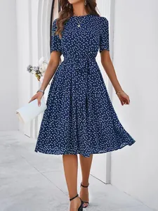 Elegant navy blue polka dot midi dress with short sleeves and a stylish belted waist design.