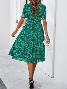 Back view of a stylish green short-sleeve polka dot pleated maxi dress for summer.