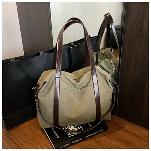Vista dettagliata di una borsa pendolare in tela verde oliva con cinturini in pelle.