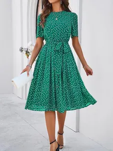 Detailed view of green polka dot dress showing tie waist and short sleeve style