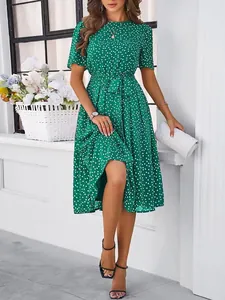 Detail of a green polka dot midi dress with waist tie and short sleeves