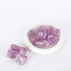 Detailed view of natural purple amethyst raw stones on a white ceramic dish