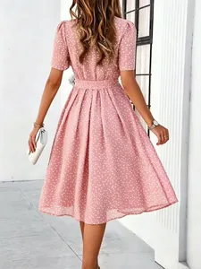Back view of a pink short sleeve polka dot midi dress with a belted waist for summer.