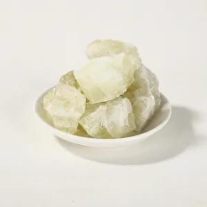 Close-up of raw natural green crystal diffuser stones on a white ceramic plate