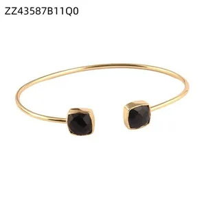Detailed view of fashion gold stainless steel open cuff bracelet with black square stones