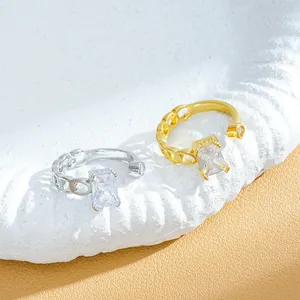 Detailed view of adjustable silver and gold rings with emerald-cut crystals