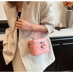 Dettaglio di una borsa a scatola trapuntata rosa con ciondolo a cuore e tracolla a catena