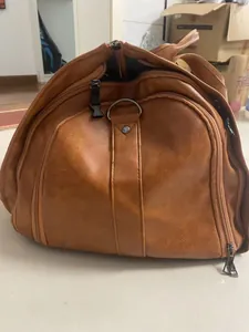 Macro detail view of the brown waterproof faux leather travel garment bag with sturdy zippers