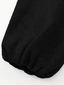 Close-up of elasticated gathered cuff detail on a black soft bomber jacket