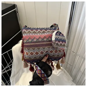 Detailed view of bohemian woven crossbody bag with colorful tassels and patterned strap