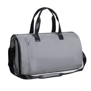 Detailed view of the grey convertible garment duffle bag with sturdy black handles.