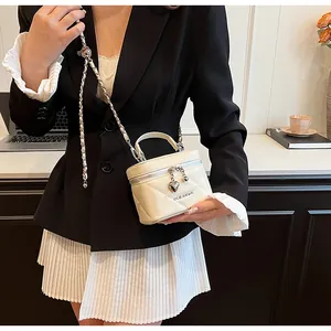 Elegante borsa box bianca trapuntata con cerniera a cuore e tracolla a catena.