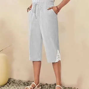 Detail view of casual light gray cropped pants with elegant white lace trim at the hem