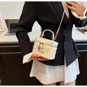 Elegante borsa a scatola trapuntata bianca con ciondolo a cuore tenuta da una modella