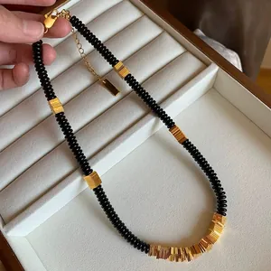 Close-up of natural black coconut shell necklace with gold-plated copper alloy details
