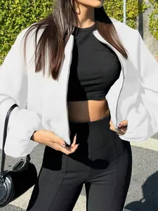 Close-up of a stylish white cropped bomber jacket for women in an outdoor setting.