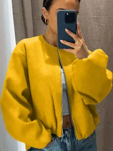 Detailed macro view of a vibrant yellow soft bomber jacket featuring a silver zipper.