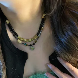 Close-up of layered bohemian necklace with natural coconut shell and sun pendant