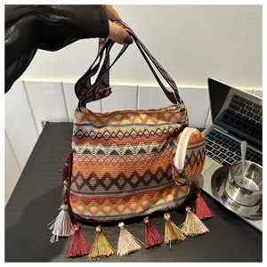 Close-up of ethnic style shoulder bag with colorful geometric patterns and tassels