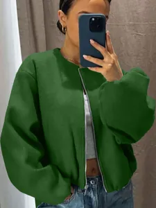Close-up detail of a soft green zip-up bomber jacket worn by a model in a mirror selfie