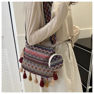 Side view of bohemian ethnic woven crossbody bag with colorful tassels on a female model