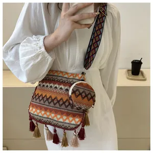 Bohemian style woven shoulder bag with colorful tassels and a matching coin purse on a model.