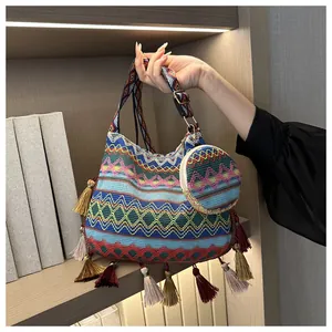 Detail view of ethnic style knit shoulder bag with colorful tassels and matching round pouch