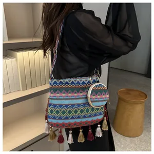 Bohemian woven shoulder bag with colorful tassels and a matching coin purse shown on a model