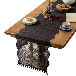 Elegant black French lace table runner with floral embroidery and delicate pom-pom trim
