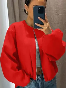 Detail view of a stylish vibrant red oversized bomber jacket with a silver front zipper